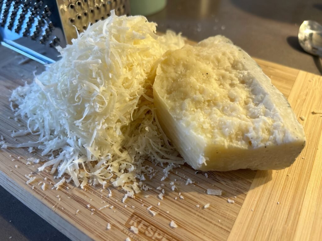 Ein Stück Pecorino Romano mit geriebenem Käse