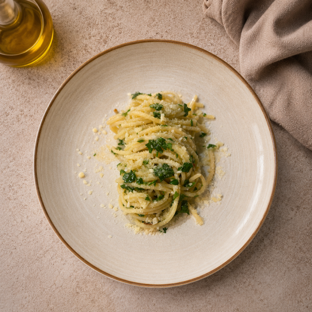 Fertige Spaghetti Aglio e Olio e Peperoncino mit Parmesan Petersilie und Kochfond servieren