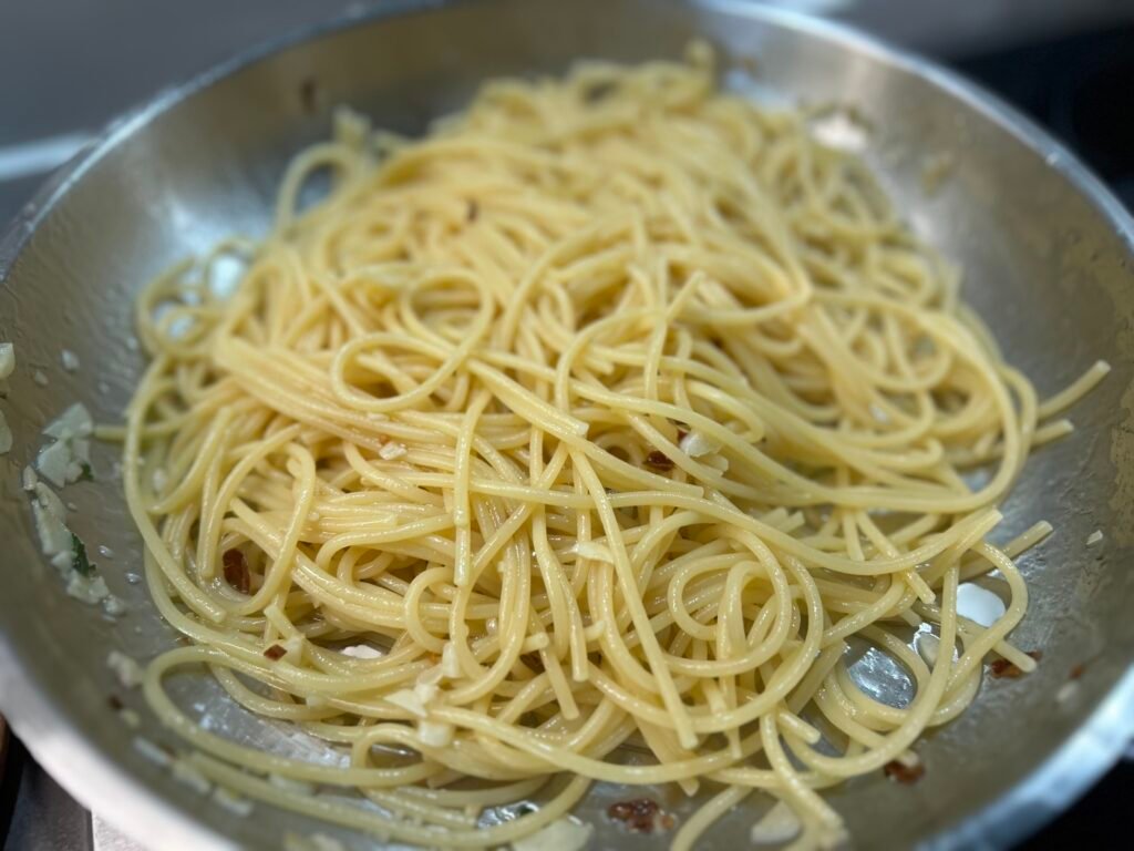 Vorgegarte Spaghetti direkt in die Pfanne für Spaghetti Aglio e Olio e Peperoncino geben