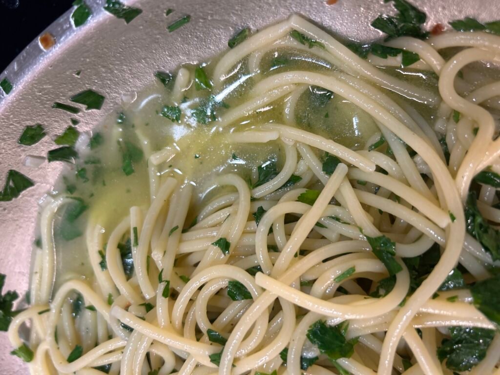 Spaghetti mit Nudelwasser kräftig durchschwenken und Spaghetti Aglio e Olio e Peperoncino emulgieren