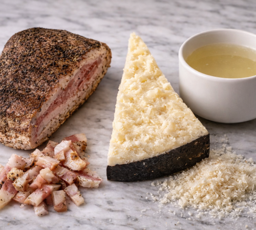 Guanciale, Pecorino Romano und Nudelwasser liegen frei auf einer Marmorplatte